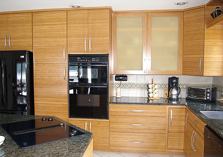 Bamboo kitchen cabinets in combination with black kitchen appliances and natural stone countertops