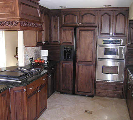 Stained oak kitchen cabinets in combination with natural stone countertops and stainless steel appliances