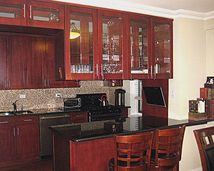 Glass door kitchen cabinets in combination with granite countertops and mosaic tile backsplash