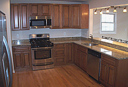 Nice room with stock kitchen cabinets, wood floor and stainless steel appliances