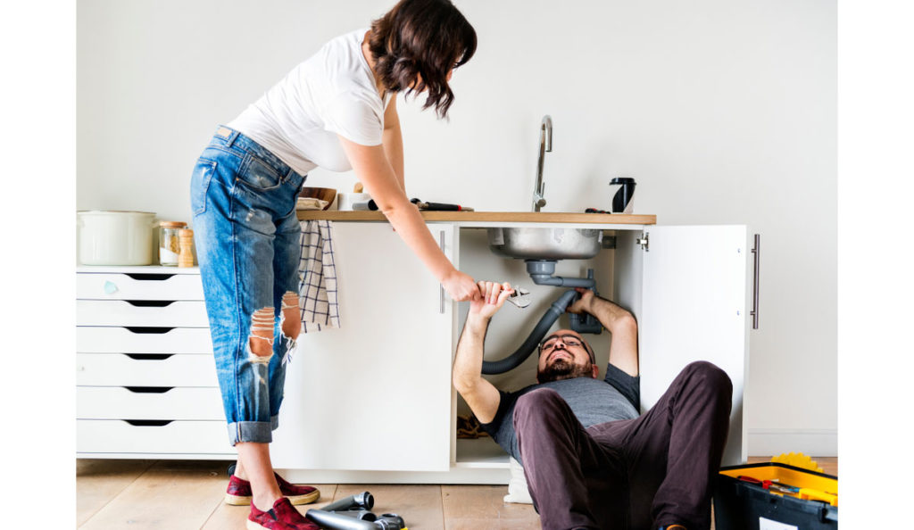 Couple fixing kitchen sink