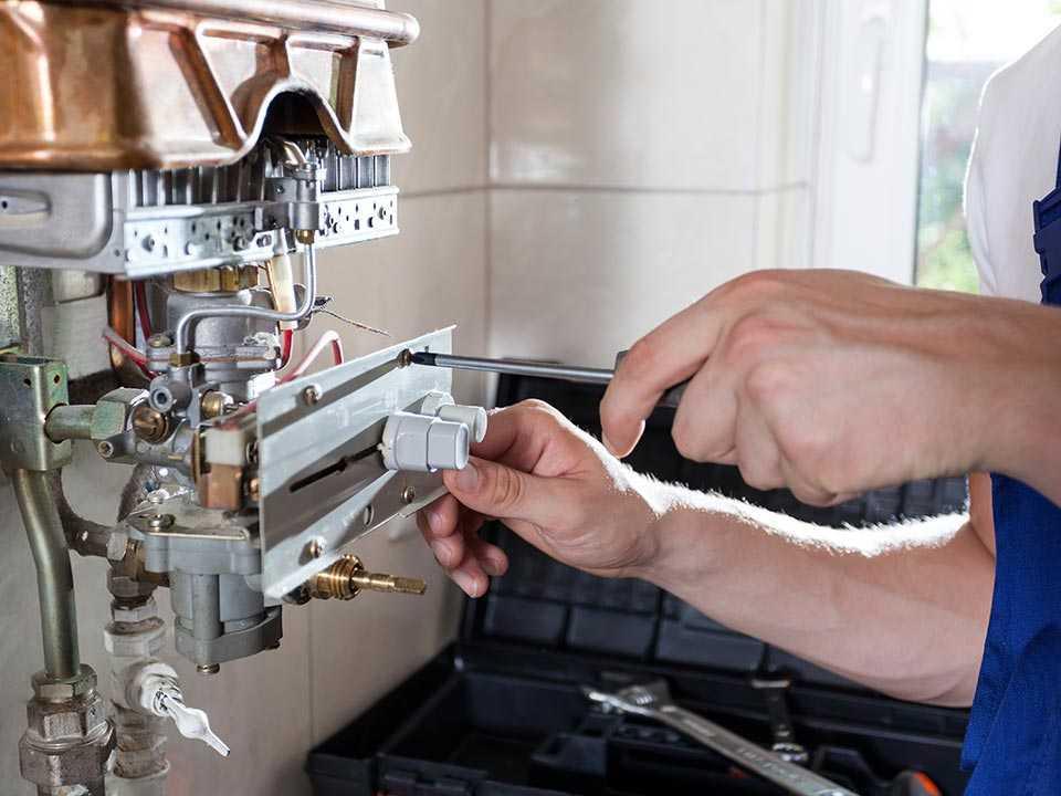 A professional does kitchen boiler maintenance.